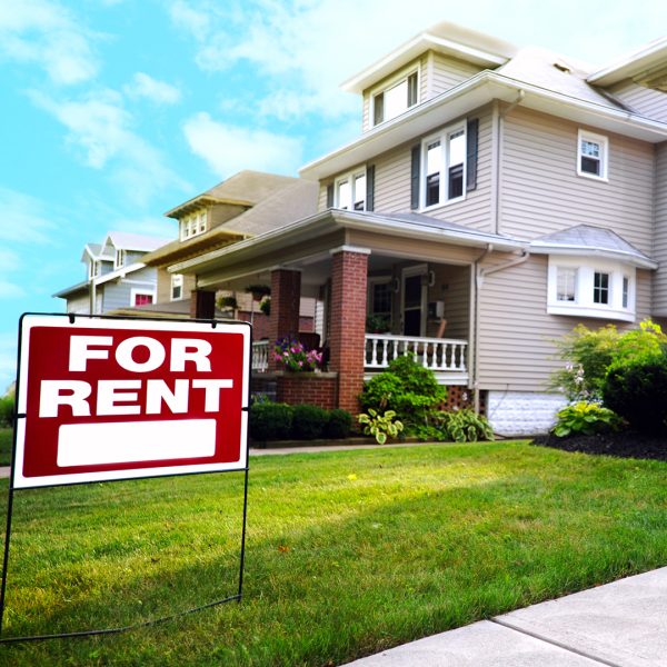 A house with a for rent sign in the front yard