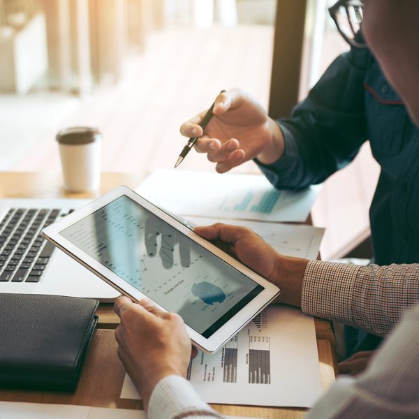 Two investors looking at information on a tablet