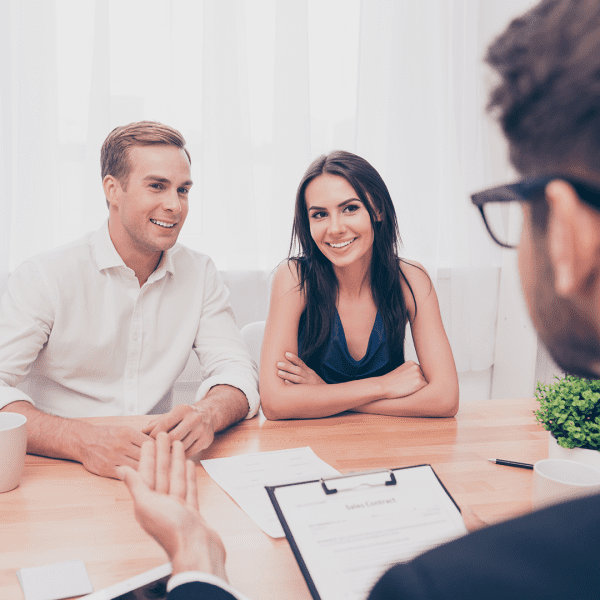 A young couple speaking with a real estate manager