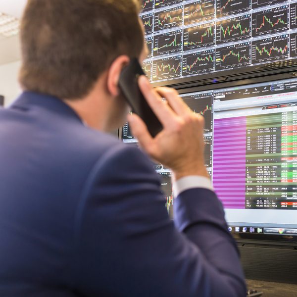 A stock trading looking at multiple computer screens