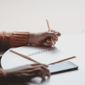 woman writing plan in notepad